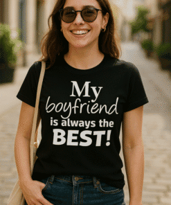 - Szemüveges nő a városi utcában, fekete pólóval, ami az "My boyfriend is always the BEST!" felirattal rendelkezik.