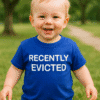 Menő kék gyerekpóló "Recently Evicted" felirattal, parkos háttérrel.
