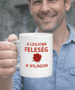 Férfi kézben egy fehér bögre, melyen a "A legjobb feleség a világon" felirat és piros rózsa látható.