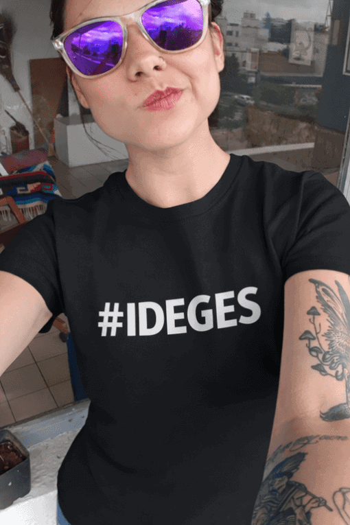 1. Nő sötét pólóval és napszemüveggel, városi tetőn, barátságos arckifejezés.