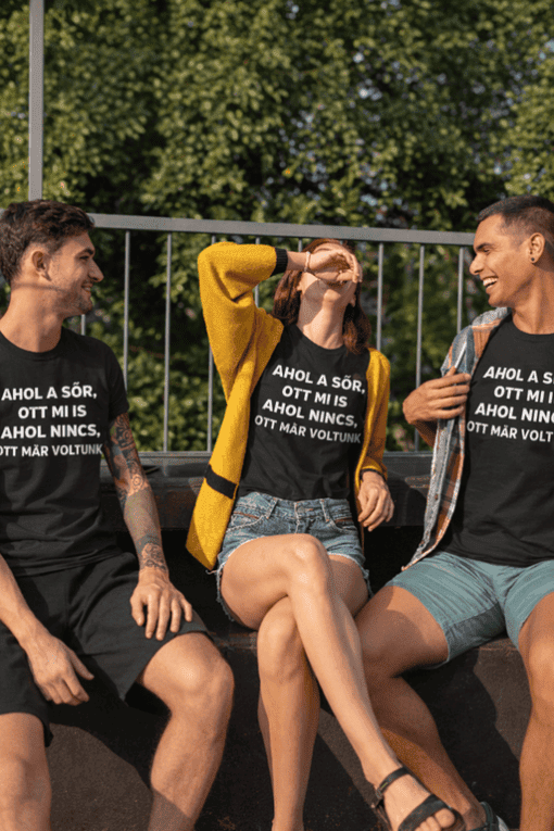 Ünnepi baráti társaság beszélget és nevet túl azokon a pólókon, melyeken magyar felirat olvasható.