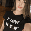 Személyes stílusú portré egy fiatal nővel, aki fekete pólót visel, "I LOVE MEN" felirattal, modern b.