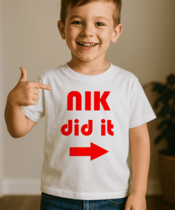 Gyerek fiú póló, "NIK did it" felirattal, piros nyíllal, otthoni környezetben.