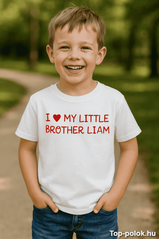 Gyermek mosolyogva áll a természetben, fehér pólón, amelyen a "I love my little brother Liam" felira.
