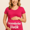 A kép egy mosolygó női modellről, aki rózsaszín pólót visel, rajta a "Decemberben jövök" felirattal.