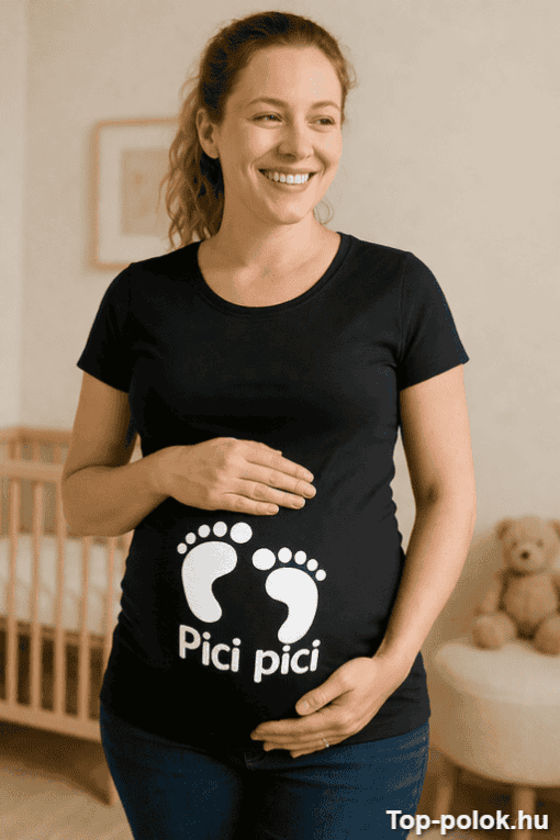 Baba várandós nő, aki boldogan tartja a hasát, a "Pici pici" feliratú terhességi pólóban, otthoni kö.
