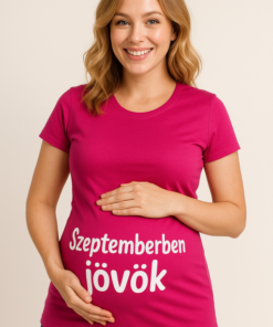 Sajátos, boldog nő a pink pólón, amelyen "Szeptemberben jövök" felirat látható.