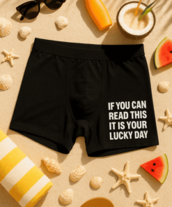 Fekete férfi boxer rövidnadrág napozóruházattal és nyári strandkiegészítőkkel.