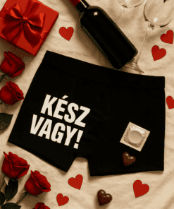 Vörösbor, ajándék doboz és szív alakú csokoládék romantikus hangulatban.