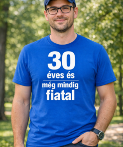 30 éves és még mindig fiatal feliratú kék pólós férfi, parkban, napsütéses időben.