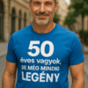 50 éves vagyok, de még mindig legendás feliratú kék póló férfi portréja városi környezetben.