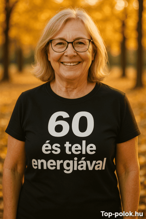 60 és tele energiával feliratú női póló, őszi parkban, mosolygós idősebb nő.
