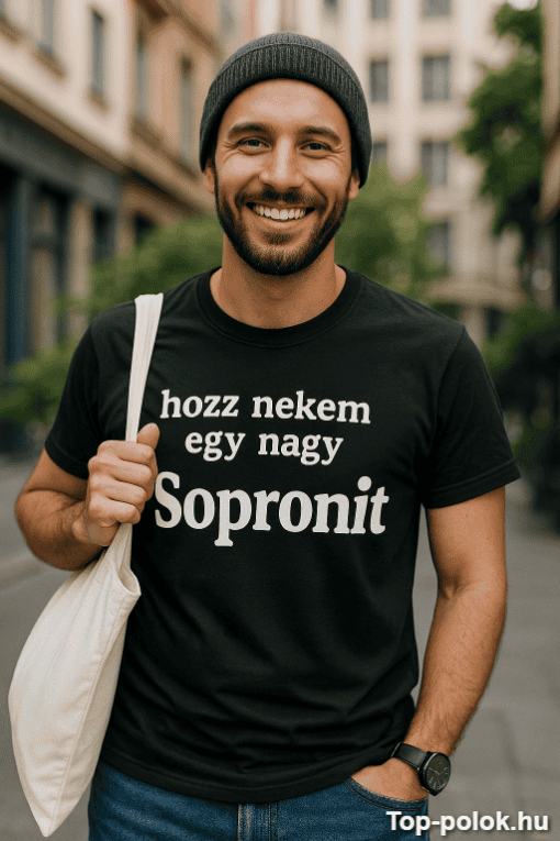 Fiatal férfi mosolyog, utcán, fekete sapkában és pólóban, Sopron felirattal.