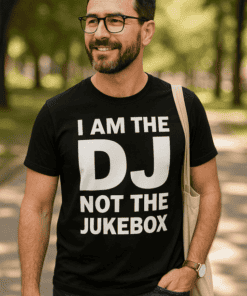 Férfi mosolygós, divatos pólóban, parkban, szöveg: "I AM THE DJ NOT THE JUKEBOX".