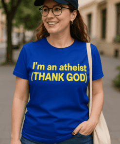Szabadtéri kép egy mosolygó nővel, aki kék pólót visel, "I'm an atheist (THANK GOD)" felirattal.