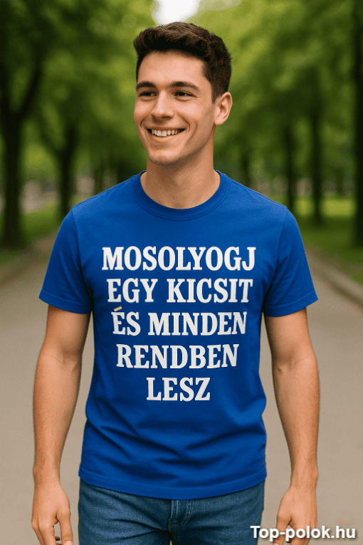 Férfi mosolyog, kék pólóval, parkban, természetes fényben, szöveg a pólón.
