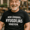 Nyugdíjas férfi mosolyog, kávézóban ül, vicces feliratos pólóban, barátságos hangulat, nyugdíjas éle.