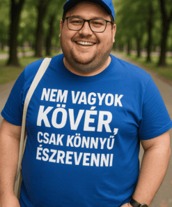 Férfi mosolygós, kék pólóval, parkban, természetes fényben, barátságos megjelenés.