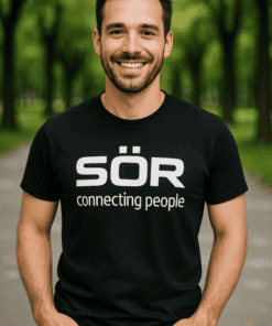 SÖR logós férfi mosolyog parkban, barátságos megjelenés, természetes környezetben.