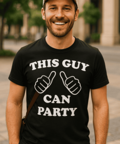 Férfi mosolygós street fashion póló, "This Guy Can Party" felirattal, városi környezetben.