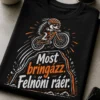 Humoros kerékpáros póló kézzel rajzolt bringával, lendületes mozgásvonallal és a „Most bringázz. Felnőni ráér.” felirattal, ahol a kerékpár átugorja a „felnőni” részt.